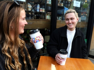 Power Of' campaign printed on coffee cup sleeves